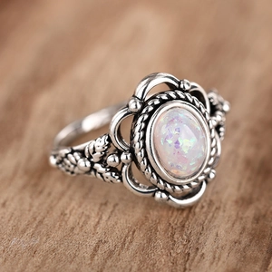 Detailed side view of vintage silver ring with oval opal stone and leaf relief details