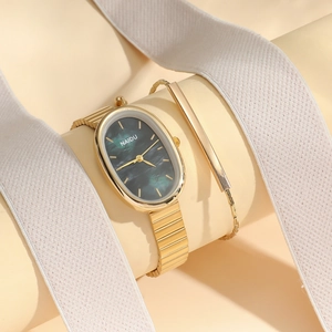 Detailed shot of oval gold quartz watch with green dial and matching gold chain bracelet