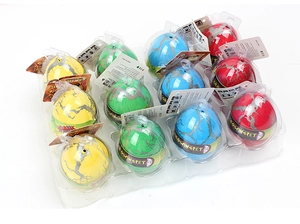 Macro view of twelve growing pet dinosaur eggs in yellow, green and red in a plastic tray