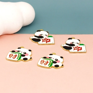 Détail de breloques panda mahjong avec bordure dorée sur fond décoratif rose et bleu
