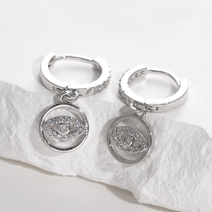 Macro detail of silver evil eye hoop earrings with micro-paved cubic zirconia stones