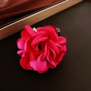 Detailed view of rose pink flocked flower necklace with soft satin fabric texture