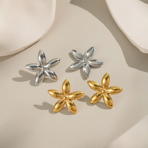 Boucles d'oreilles fleurs à cinq pétales en or 18K et argent sur fond minimaliste