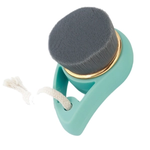 Mint green facial cleansing brush with charcoal bristles and gold ring accent
