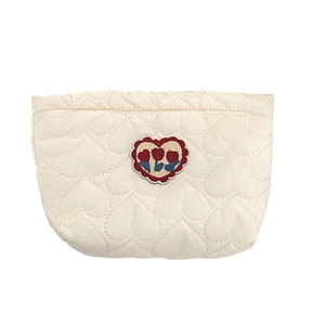 Borsa portaoggetti beige trapuntata con ricamo floreale su sfondo bianco minimale