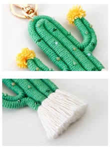 Macro detail of handmade cactus keychain with yellow pompoms and cotton tassels