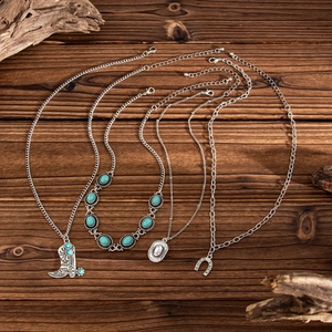 Detail of vintage bohemian necklaces with turquoise, cowboy boots, and horseshoe charms