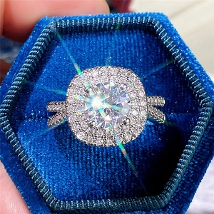 Luxury halo engagement ring with brilliant round center stone in blue velvet box