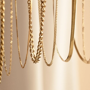 Detail of gold plated stainless steel rope, box, and herringbone chains with polished finish