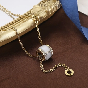 Close-up of golden cylinder pendant with cat eye stone and sparkling crystals detail