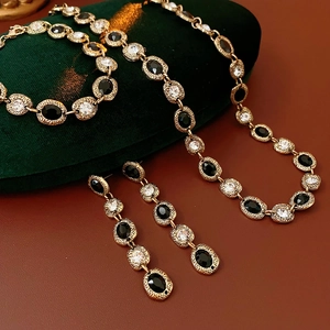 Parure de bijoux vintage avec strass ovales et métal doré sur velours vert foncé