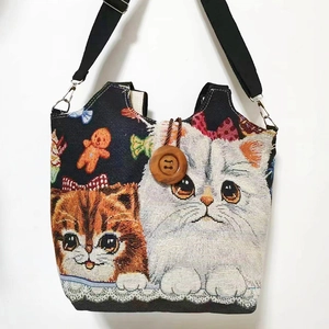 Detail des Holzknopf-Verschlusses und Katzen-Stickerei auf der Canvas-Tasche