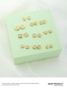 Macro detail of various gold-plated titanium steel stud earrings with zircon inlay