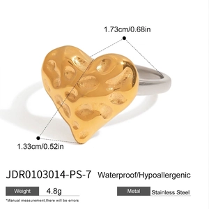 Detail view of heart-shaped two-tone stainless steel ring with hammered gold texture