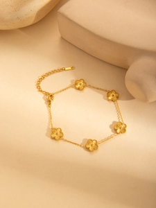 Macro detail of gold five-flower titanium bracelet with textured radial petals