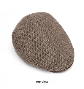 Above view of a vintage brown herringbone flat cap with detailed wool blend texture