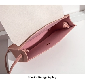 Detail view of pink crossbody bag interior lining and single compartment structure