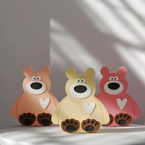 Detailed view of three cute 3D bear-shaped silicone molds in pink, beige, and orange colors