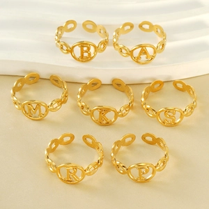 Macro shot of 18K gold plated stainless steel letter rings with hollow circular pendants