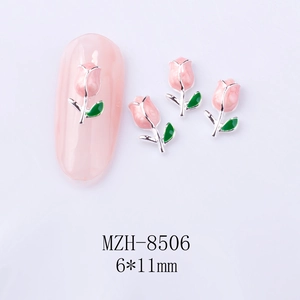 Detail shot of 6x11mm pink tulip nail charms with green leaves on a soft pink manicure