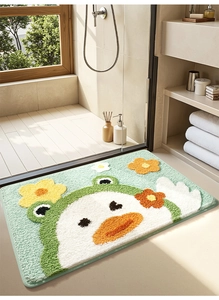 Detail of plush green frog and flower bath mat showing soft absorbent texture in bathroom