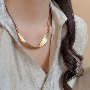 Minimalist irregular U-shaped metal pendant necklace on brown leather cord