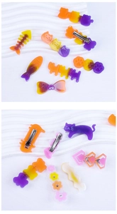 Détail de barrettes en résine dégradée en formes de chat, d'arête de poisson et de papillon