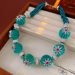Macro shot of vintage necklace with turquoise floral beads and pink rhinestone details