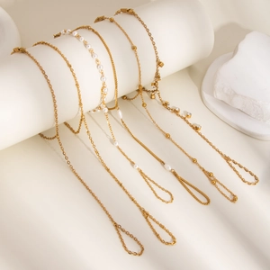 Détail de bracelets plaqués or 18 carats avec perles et zircons sur présentoir blanc