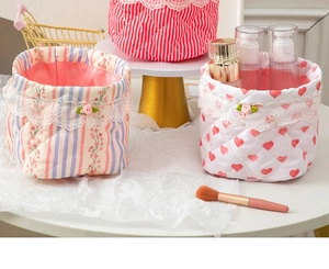 Close-up of quilted fabric storage baskets with lace trim and floral patterns