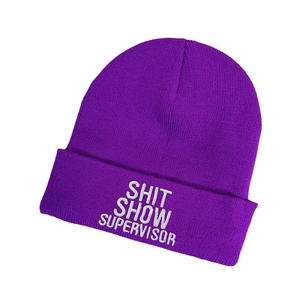 Dark purple knit beanie with white Shit Show Supervisor embroidery on a plain background