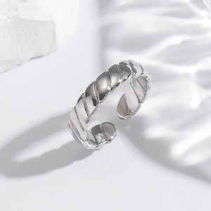 Close-up of a silver twisted copper ring with an adjustable open design on a stone