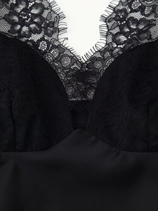Close-up of black lace V-neckline with eyelash trim and smooth satin fabric detail