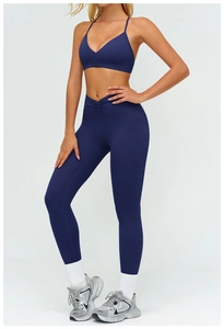 Dettaglio dei leggings yoga blu navy a vita alta con elegante fascia incrociata a V