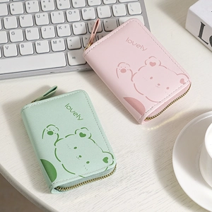 Pink and green accordion zip card wallets with cute bear pattern on a lifestyle background