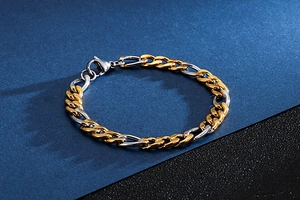 Detail of two-tone gold and silver Cuban link bracelet with polished metal texture