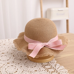 Détails de la texture du chapeau de paille avec ruban rose et bord ondulé élégant