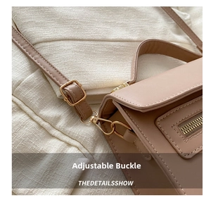 Détail de la boucle dorée réglable et des coutures fines sur un sac à main vintage carré
