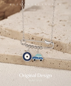 Detailed macro of S925 sterling silver paperclip necklace with evil eye and car charms