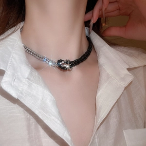 Dettaglio di una collana Y2K con perline nere e cristalli indossata da una modella