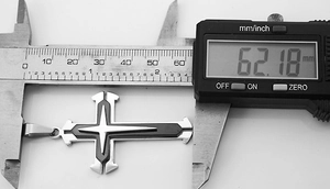 Digital caliper measuring the 62.18mm length of a triple-layered cross pendant