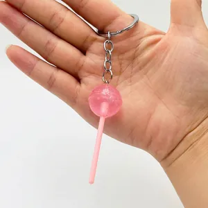 Detail of a pink transparent lollipop keychain with glitter and silver metal ring