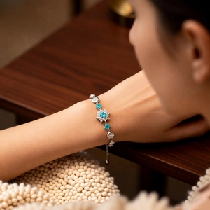 Close-up of elegant flower pendant bracelet with blue zircon stones on a female wrist