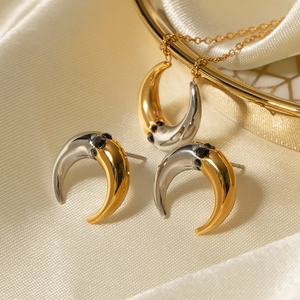 Detailed shot of two-tone gold and silver crescent jewelry set with black gemstones
