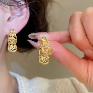 Détail de boucles d'oreilles dorées vintage avec cristaux et pampilles élégantes