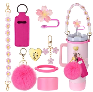 Close-up of pink flower charm strap and straw cover accessories set for tumblers