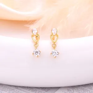 Golden heart drop earrings with waterdrop zircon on elegant white ceramic decor