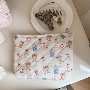 Close-up of quilted cotton makeup bag with cute cartoon animals and simple wish label