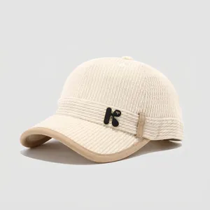 Detail of kids' corduroy baseball cap showing the K badge and ribbed fabric texture