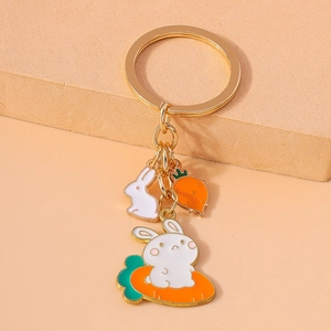 Detail of bunny and carrot metal keychain with colorful enamel coating on gold ring